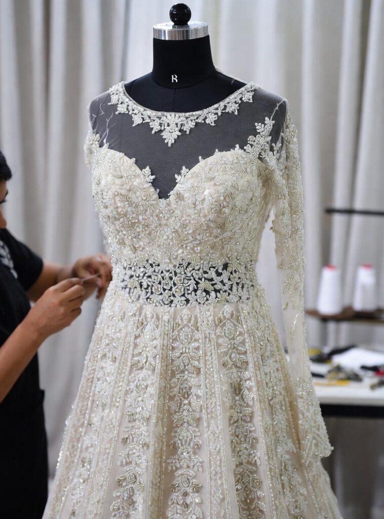 “Bridal dress being hand-embroidered by a tailor.”